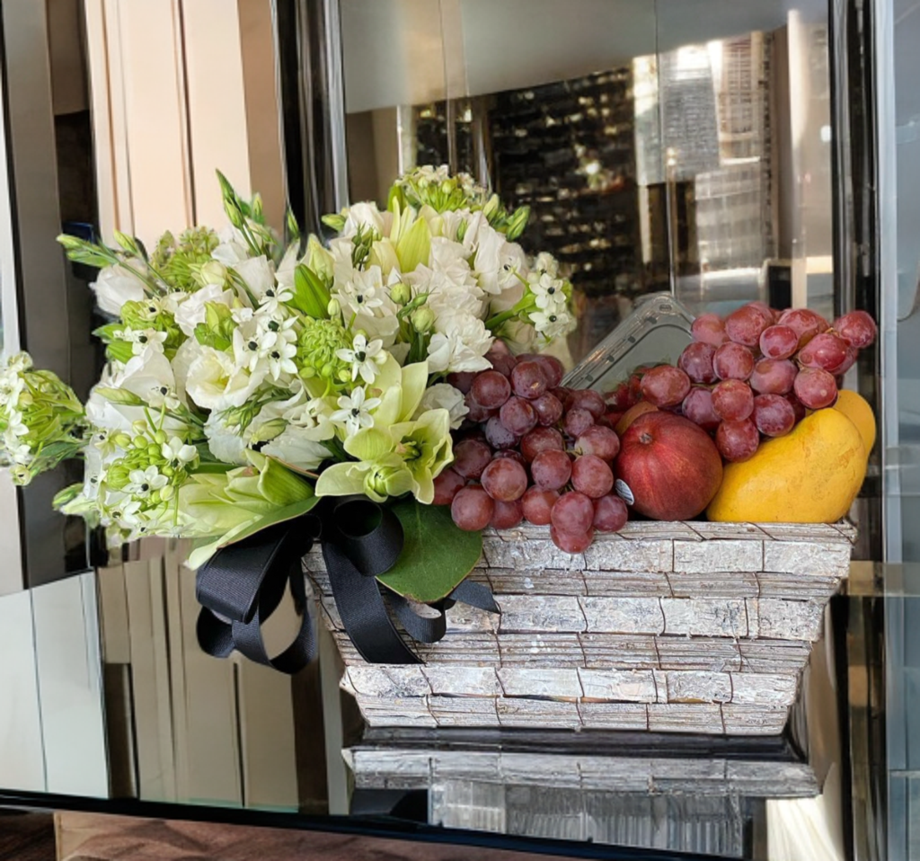 Canasta de frutas y flor blanca